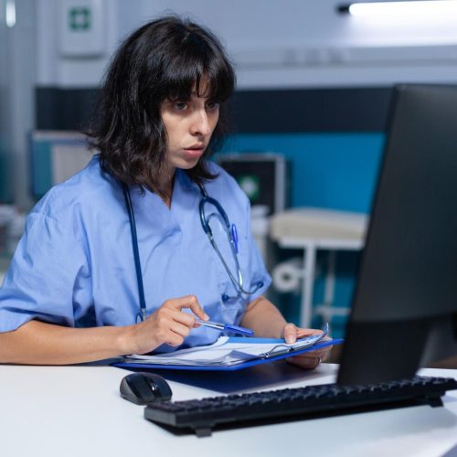 medical-assistant-analyzing-documents-files-monitor-night-nurse-looking-computer-working-healthcare-appointment-with-checkup-papers-doing-overtime-work-desk_482257-30373